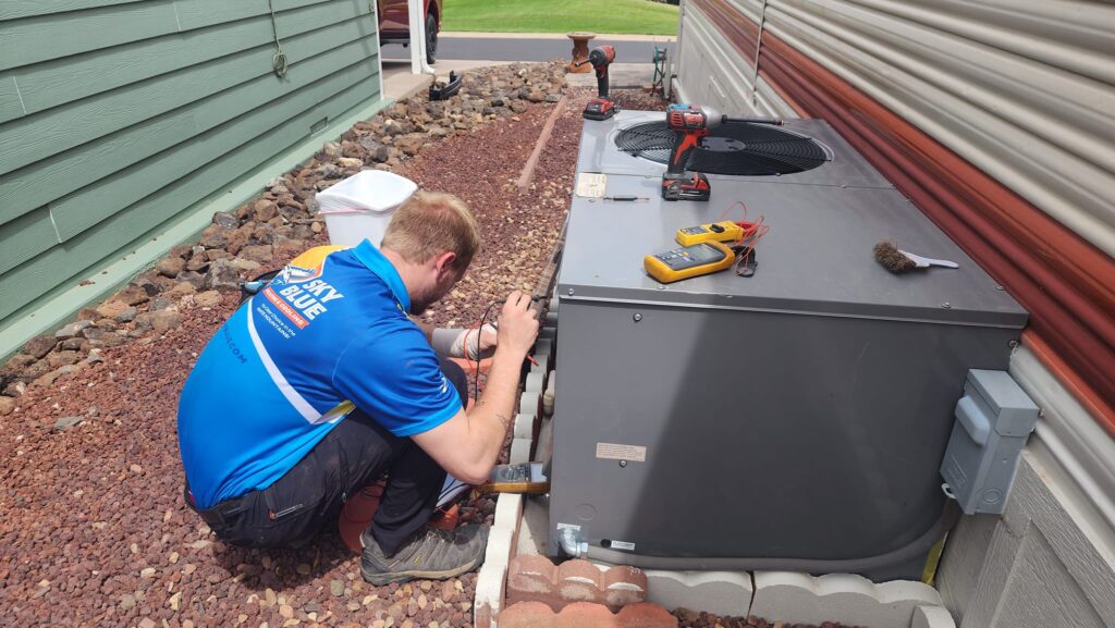 A technician performing AC installation at an Arizona home